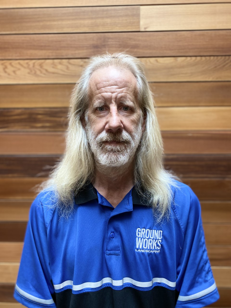 Photo of a man with gray blonde hair and Ground Works polo, looking at the camera.