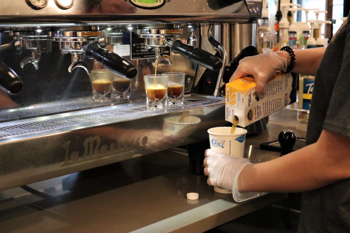 Photo of someone preparing drip coffee and a hot tea in a to-go cup.